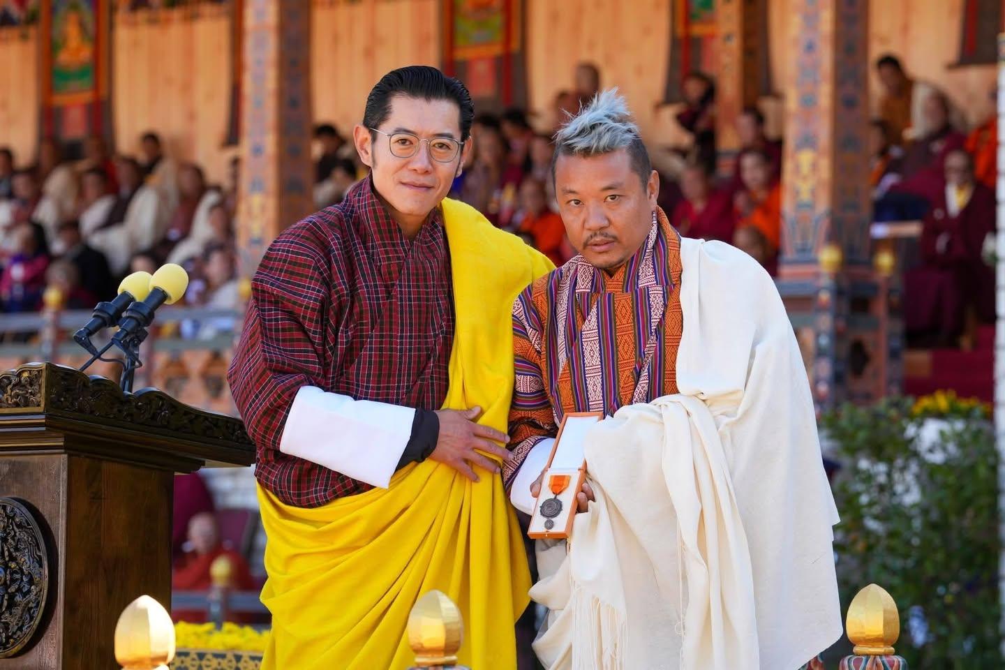 Karma Kelvin Dorji receiving the National Order of Merit from His Majesty The King